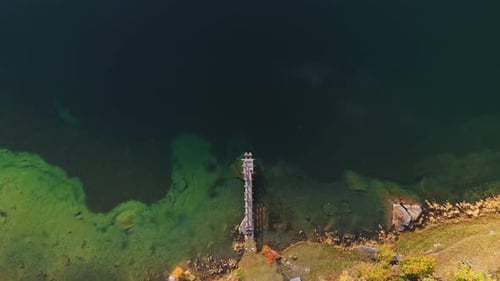 Aerial Top View of Wooden Little Bridge in Mountain Lake in Autumn