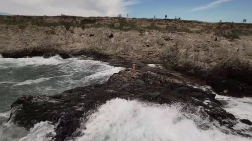 Girls are Photographed on a Rock Near the Sea