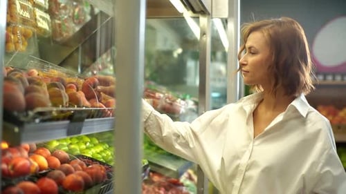 Closeup of Attractive Young Woman Selecting Dried Fruits in Grocery Store Supermarket