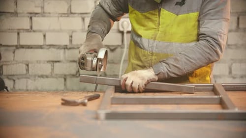Metalworker Using Grinding Tool on Metal
