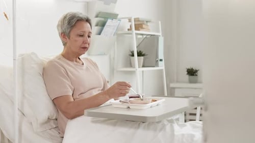 Female Patient Having Meal in Hospital Ward