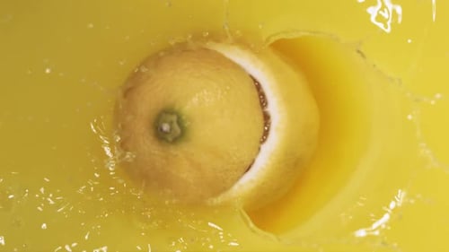 Lemon Splashing into Yellow Liquid