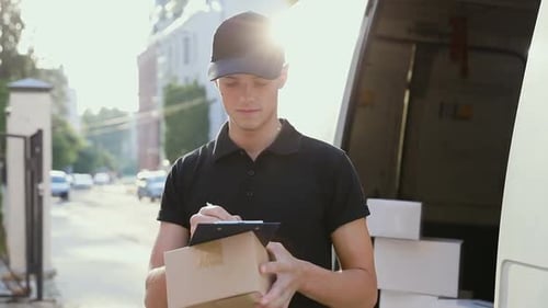 Delivery Service. Courier With Box In Hands Near Car Outdoors