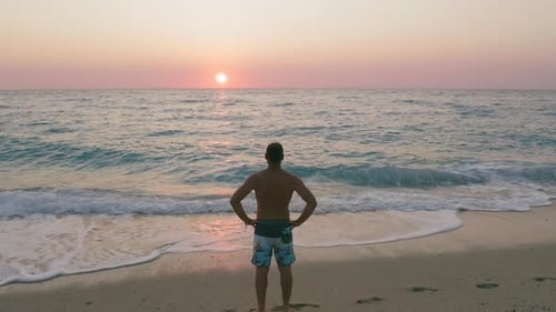 Static Drone View of Man Silhouette on the Beach Enjoying Sea Water Surface with Calm Waves at