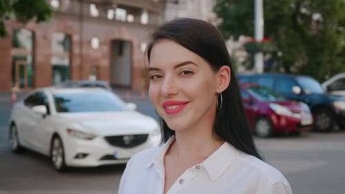 Portrait of Beautiful Smiling Brunette Woman on a City Background. Young Successful Businesswoman