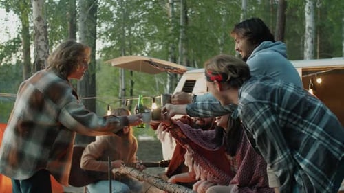 Des amis qui boivent des toasts près d'un feu de camp