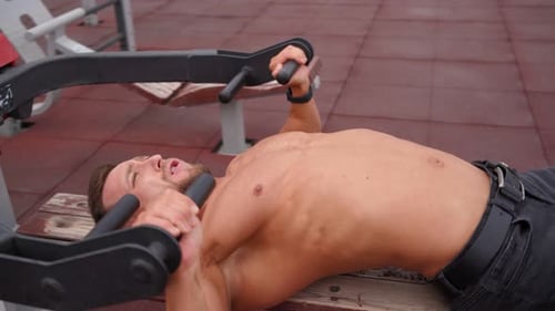 Muscular Man Doing an Exercise for the Pectoral Muscles in a Special Simulator
