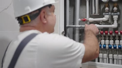 Plumber Adjusts Valves on New Plumbing Installation
