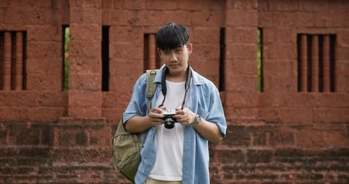 Man taking a photo and looking at camera at ancient temple