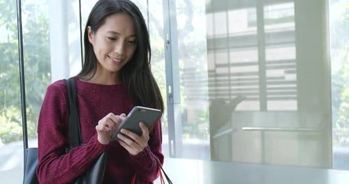 Woman Uses Smartphone in Modern Urban Setting