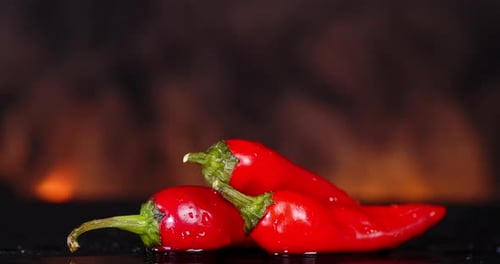 Shiny Red Chili Peppers with Fire Background