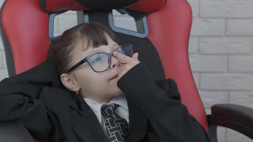 Girl in Suit Relaxes in Gaming Chair