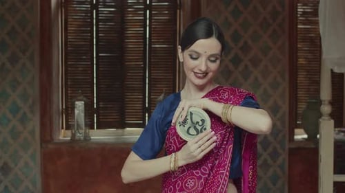 Mujer bonita en sari sosteniendo instrumento meditativo