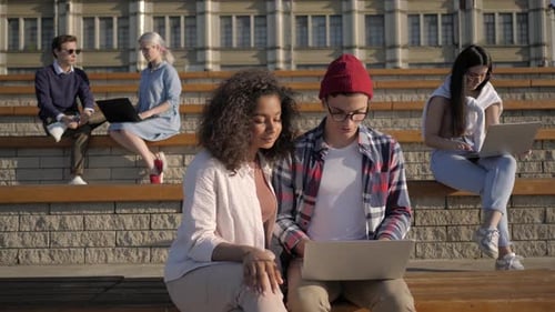 Students Doing Projects on Laptops Outside the University.