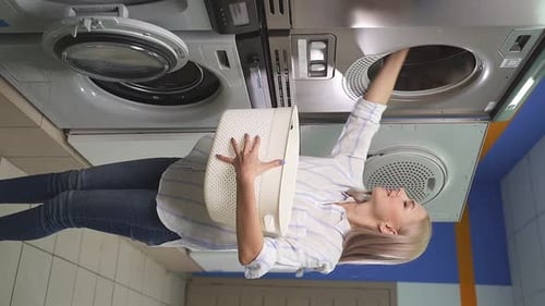 Woman Loads Clothes in Commercial Washing Machine