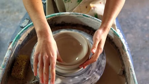 Mains d'une potière fabriquant un pot