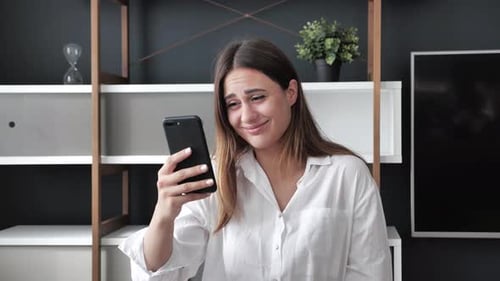 Woman Uses Phone, Reacts With Facial Expressions
