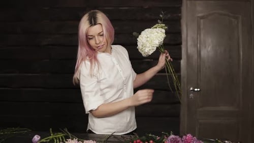 Front View of a Tender Young Girl in White Shirt Arranging Flower By Flower in Bouquet