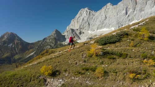 4K Aerial View One Woman Hiking in Alpine Mountain Landscape on Sunny Autumn Day