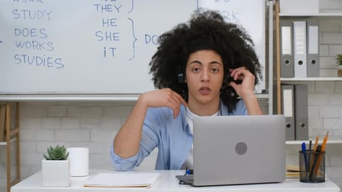 Online Tutor Explains English Grammar at Desk