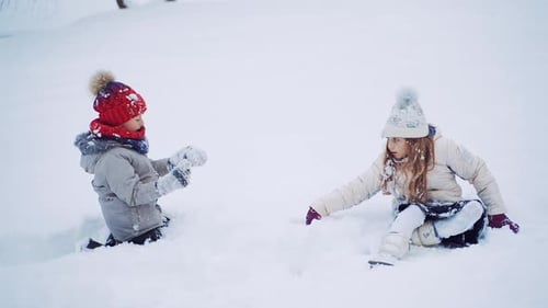 Schöne Kinder heben sich draußen vom weißen Schnee ab.