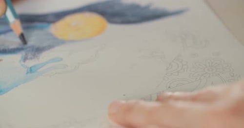 Close up of an artist drawing with colored pencils