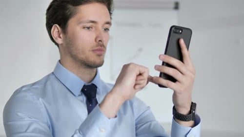 Gros plan d'un jeune homme d'affaires utilisant un smartphone au travail