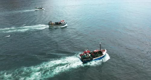 Fischerboote segeln bei Sonnenuntergang zu Fischen auf ruhiger Meeresoberfläche im Sommer