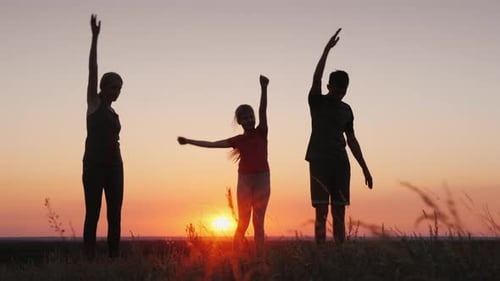 Junge Familie mit Kind macht Übungen an einem schönen Ort bei Sonnenuntergang
