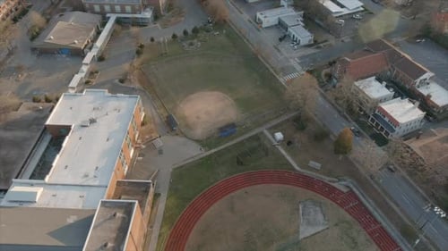 Aerial forward view over Durham downtown high school sports center, North Carolina. Baseball field,