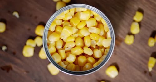 Canned Yellow Corn on Wooden Surface