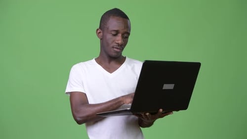 Young Adult Using Laptop on Green Screen Background