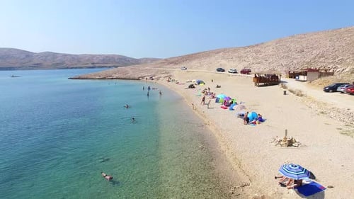 Flying above tourists on isolated beach of Pag island, Croatia