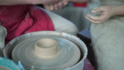 Potter enseigne la poterie à une petite fille