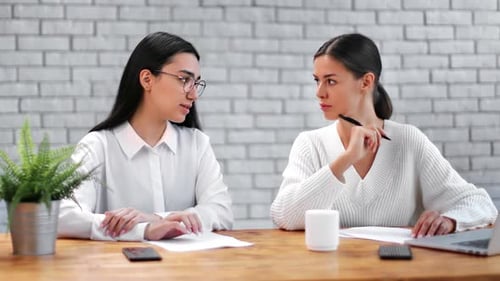 Two Stylish Diverse Young Businesswoman Talking Collaborating in Office