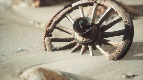Abandoned Wooden Wagon Wheel in Dry Desert Sand
