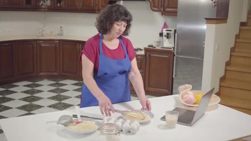 Woman Whisking Ingredients in Kitchen