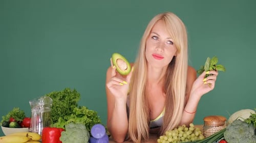 Chica tratando de elegir entre aguacate y lechuga