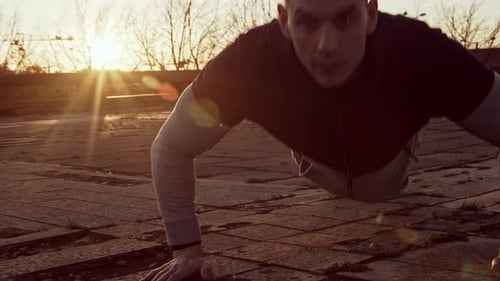 Man Doing Push-ups Outdoors at Sunset