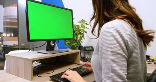 Woman Typing at Computer With Green Screen