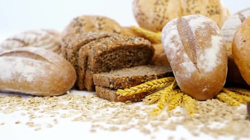 Variety of Breads Displayed with Grains and Wheat