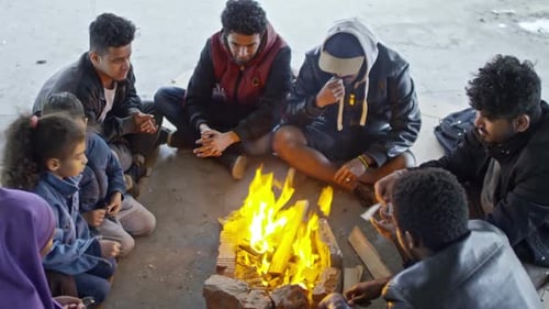 Refugiados sirios sentados junto al fuego