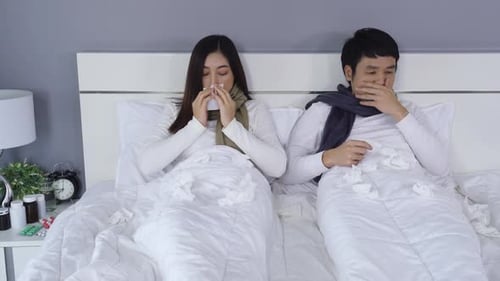 Sick Couple Lying in Bed with Cold and Flu