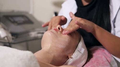 Woman Relaxing During a Rejuvenating Facial Massage