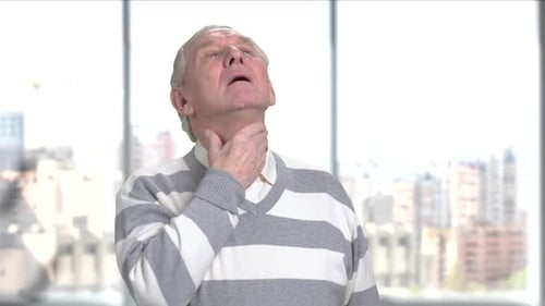 Senior Man with Sore Throat Indoors