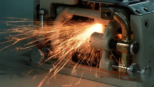 The Process of Sharpening a Blade on a Skiving Machine. Many Sparks Fly Out