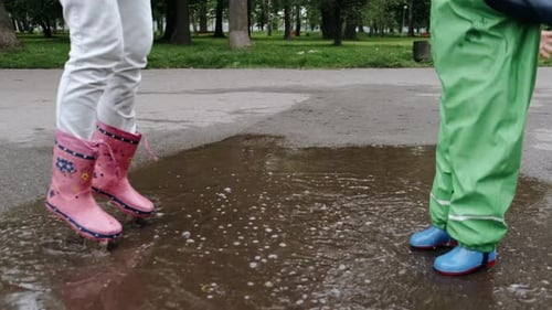 Funny Kid in Rain Boots Playing in a Rain Park