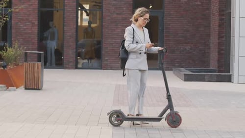 Femme d'affaires conduisant un scooter électrique