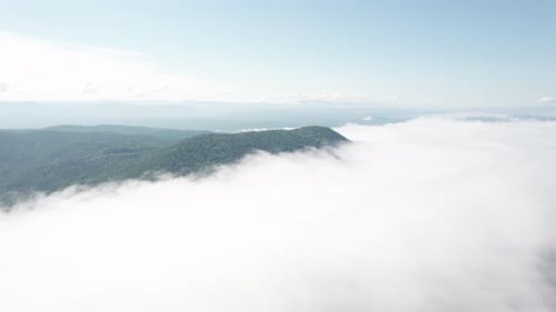 Flying Through the Clouds Above Mountain Tops