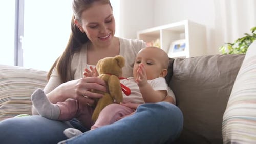 Mother and Baby Playing with Teddy Bear at Home